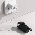 Luminomo Go portable power bank in black charging from a USB-C wall adapter.