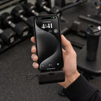 Person holding the black Luminomo Go portable power bank after a workout.