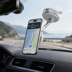 Luminomo Orbit magnetic phone mount attached inside a car for hands-free GPS navigation while driving on a coastal road.