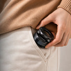 Person placing the compact Luminomo Orbit magnetic phone mount into a pocket, highlighting its portable and travel-friendly design.
